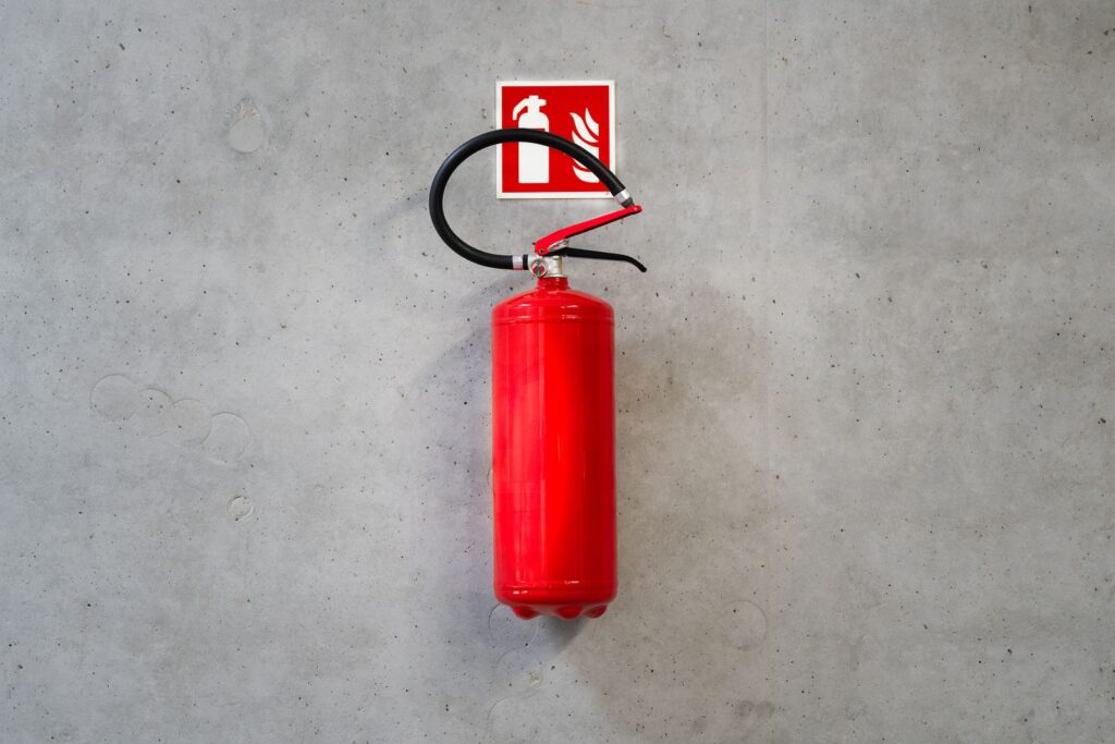 Extintor de incêndio com placa de sinalização na parede